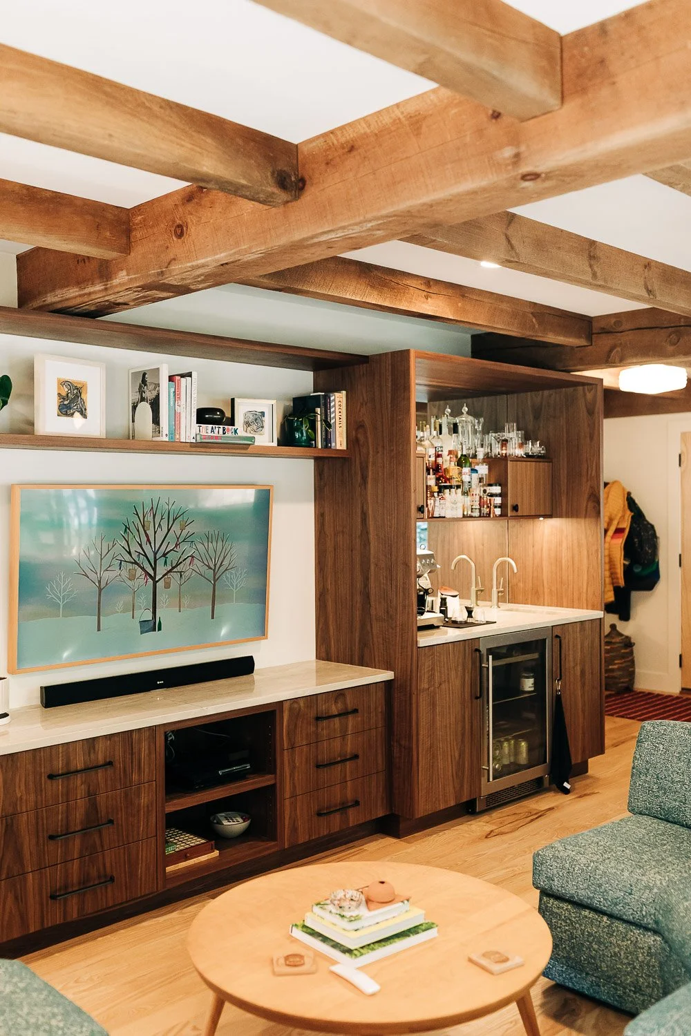 Custom black walnut built-in media and wet bar with integrated storage, beverage fridge, open shelving, and millwork cabinetry in mountain home near Lake Lure North Carolina