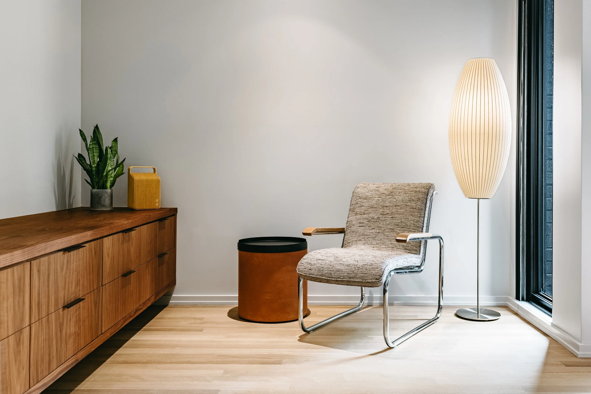 Custom woodwork by Sunnyside Millwork Custom 20-foot floating black walnut dresser with grain-matched veneer drawer fronts, precision scribed to fit irregular walls in Kernersville, North Carolina