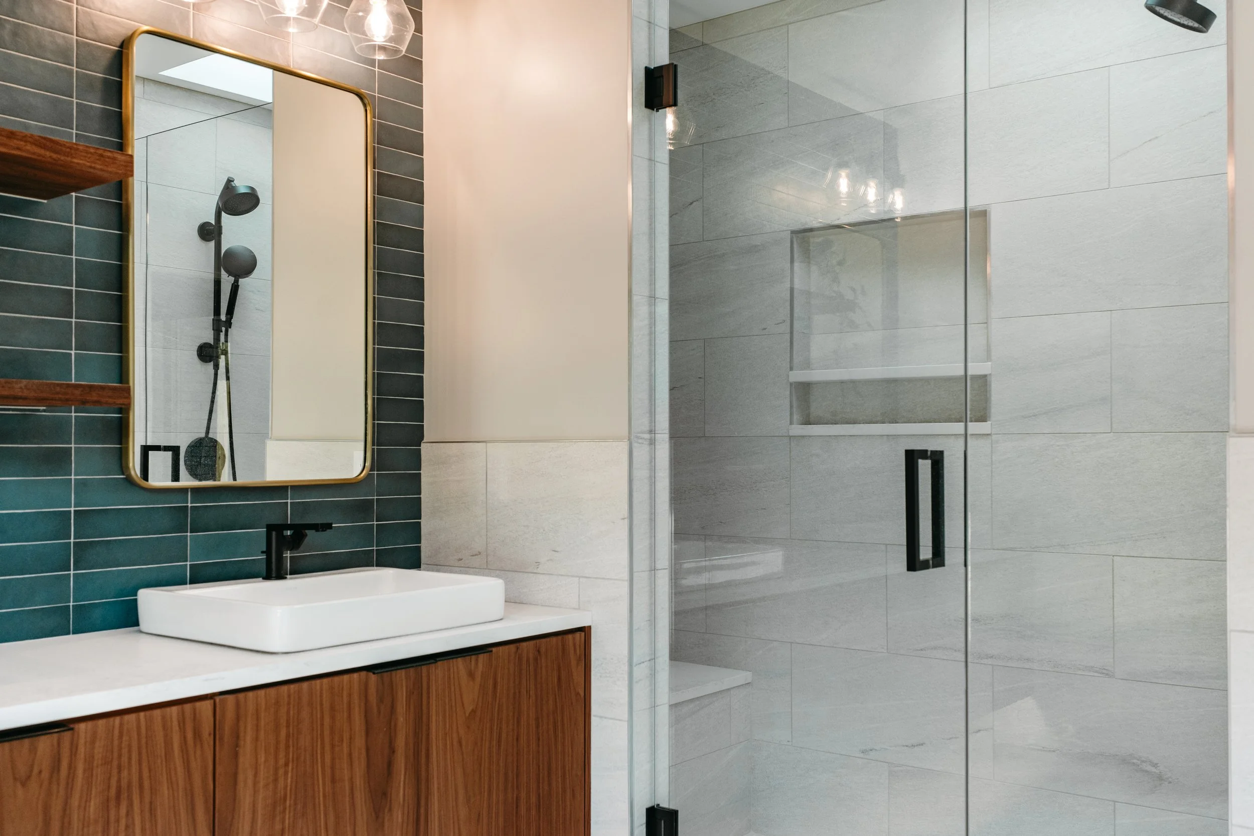 Custom woodwork by Sunnyside Millwork Floating walnut vanity with integrated lighting, quartz countertop, and custom millwork storage in modern bathroom design in Kernersville, North Carolina