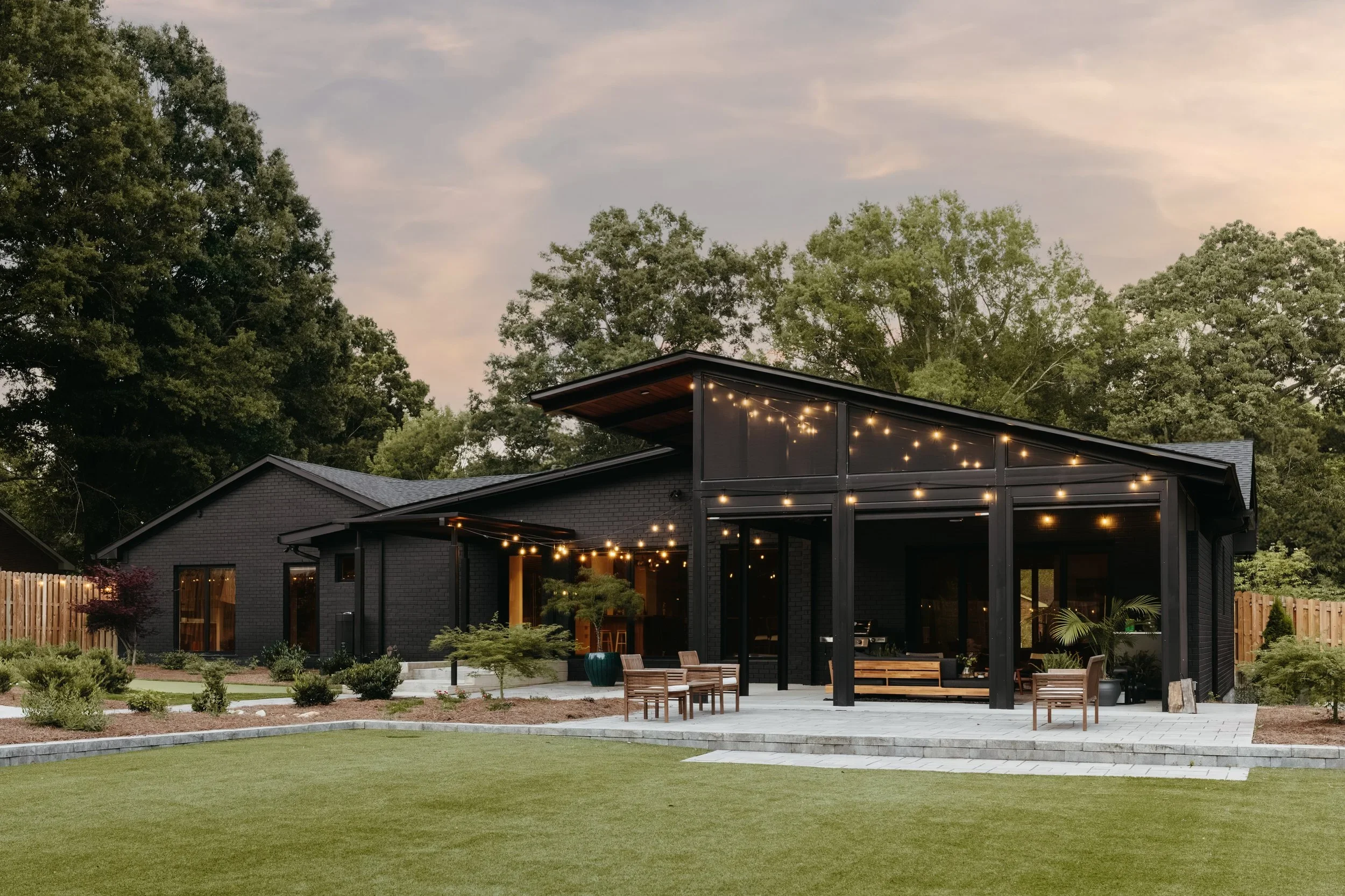 Rear view of renovated ranch home in Kernersville NC with covered outdoor living area, modern addition, and indoor outdoor connection