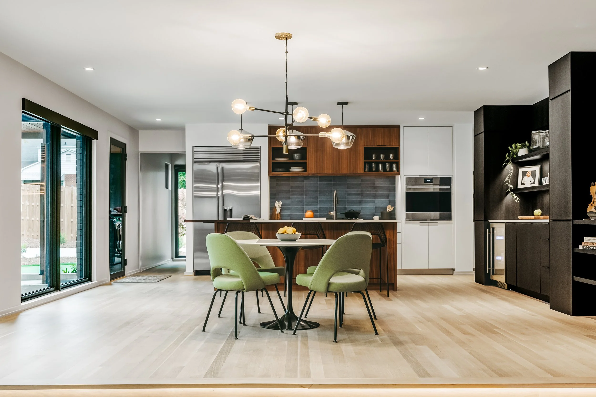 Custom woodwork by Sunnyside Millwork Open concept Two-tone kitchen with grain-matched walnut uppers, white lacquer cabinets, and integrated millwork island with quartz surface in Kernersville, North Carolina