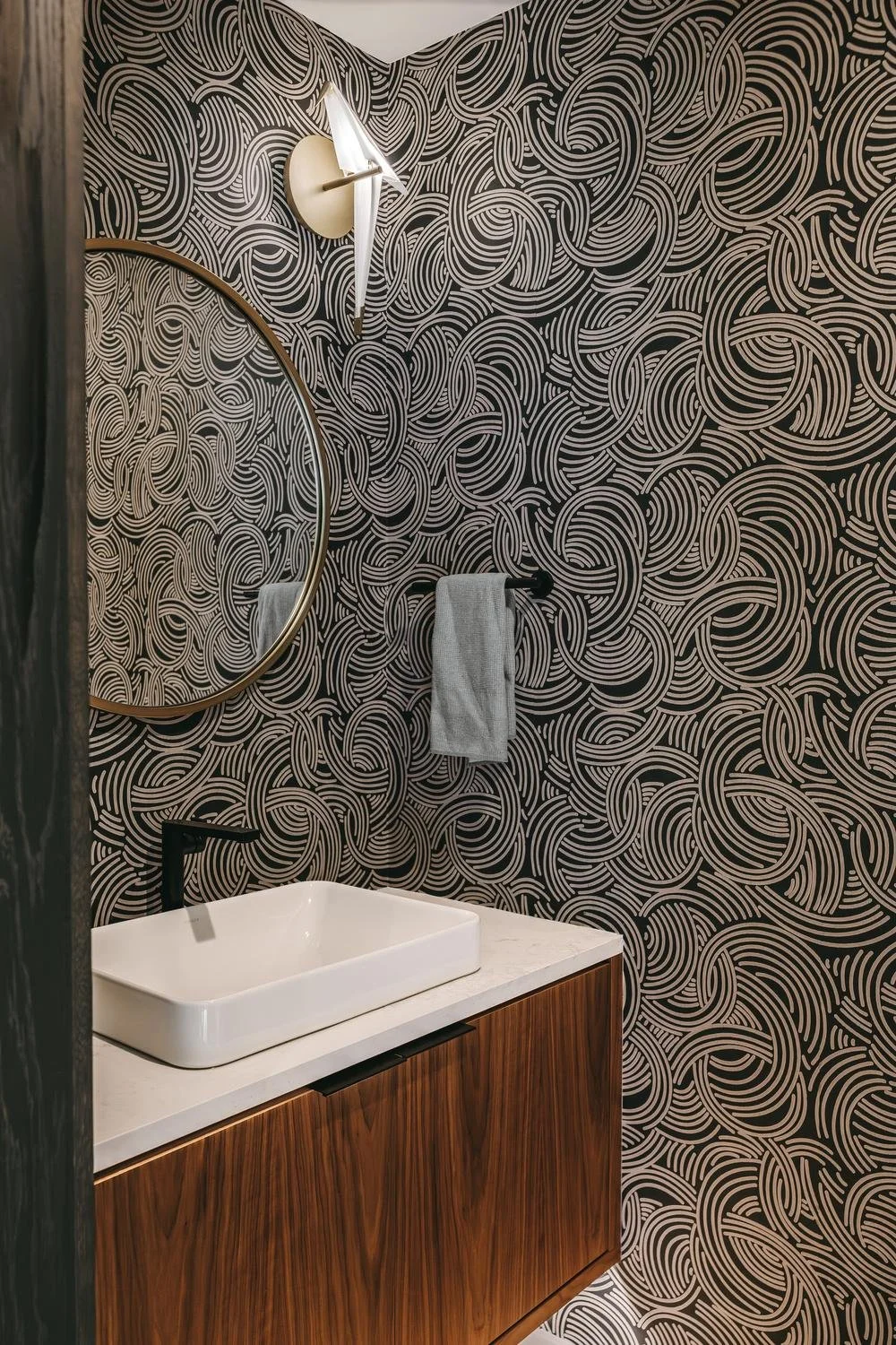Detail of custom walnut vanity with grain-matched panels and concealed pocket door system in modern bathroom remodel Kernersville NC