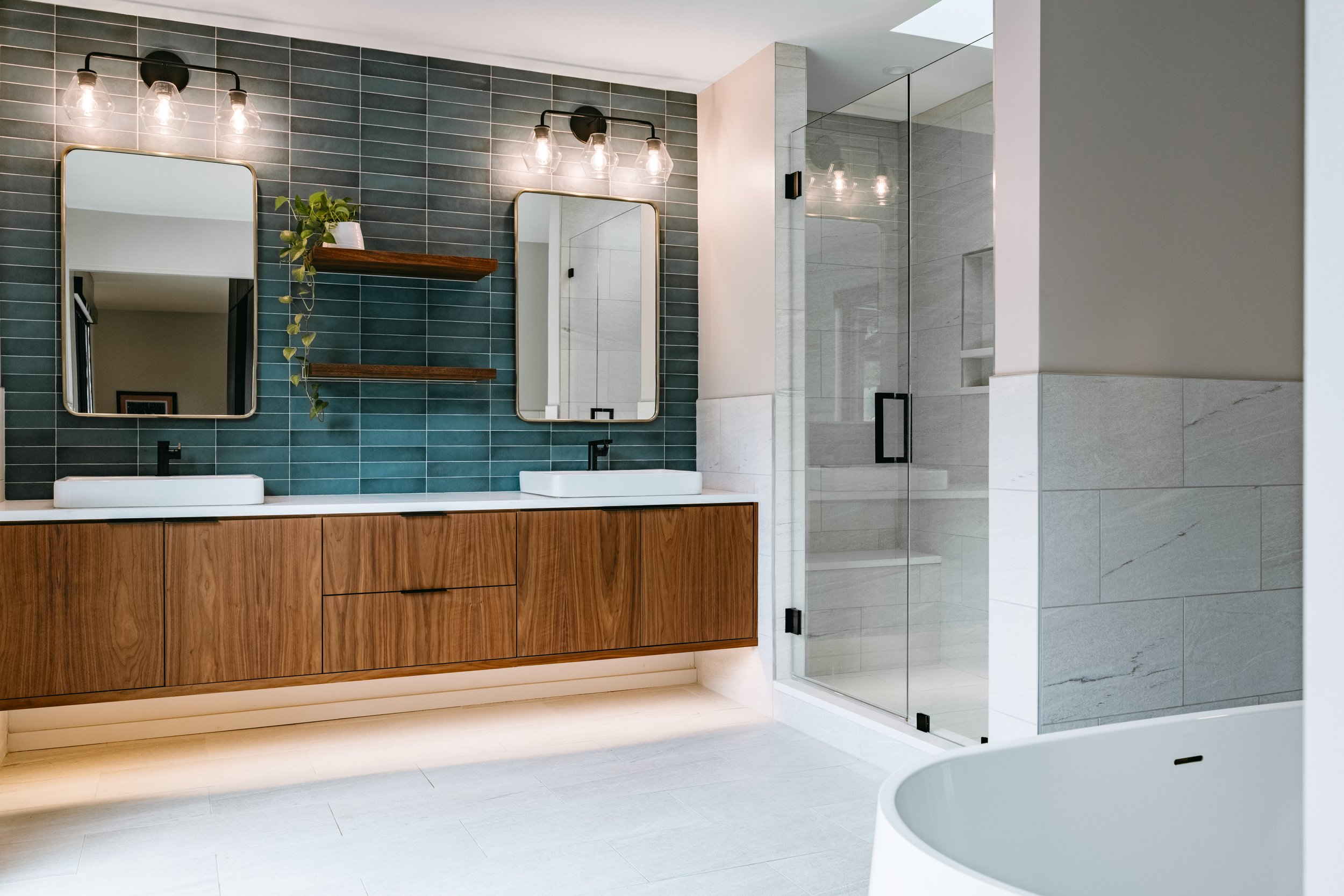 Custom woodwork by Sunnyside Millwork Floating walnut vanity with integrated lighting, quartz countertop, and custom millwork storage in modern bathroom design in Kernersville, North Carolina