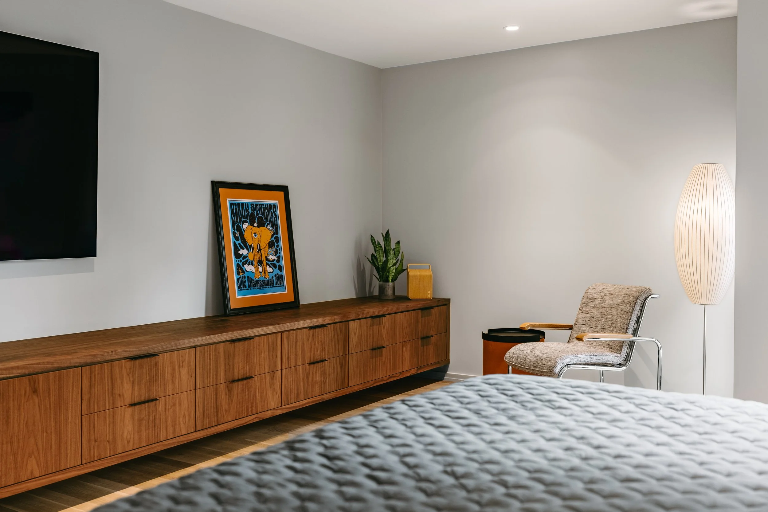 Custom woodwork by Sunnyside Millwork Custom 20-foot floating black walnut dresser with grain-matched veneer drawer fronts, precision scribed to fit irregular walls in Kernersville, North Carolina