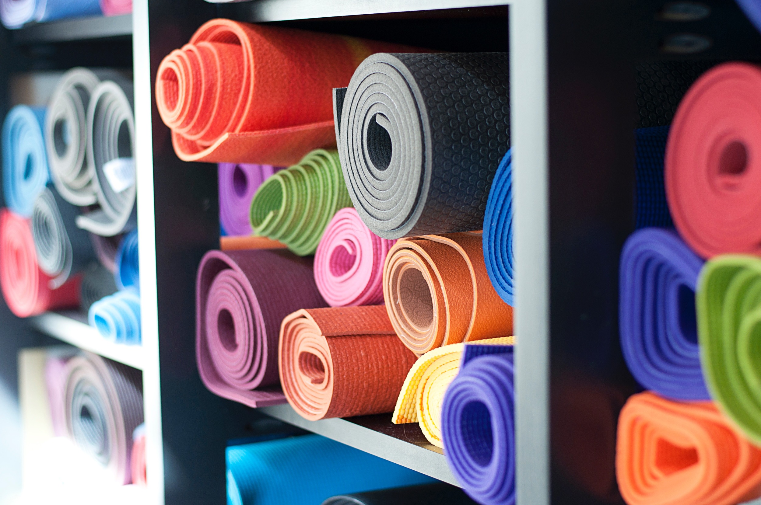 Shelves of yoga mats rolled up.