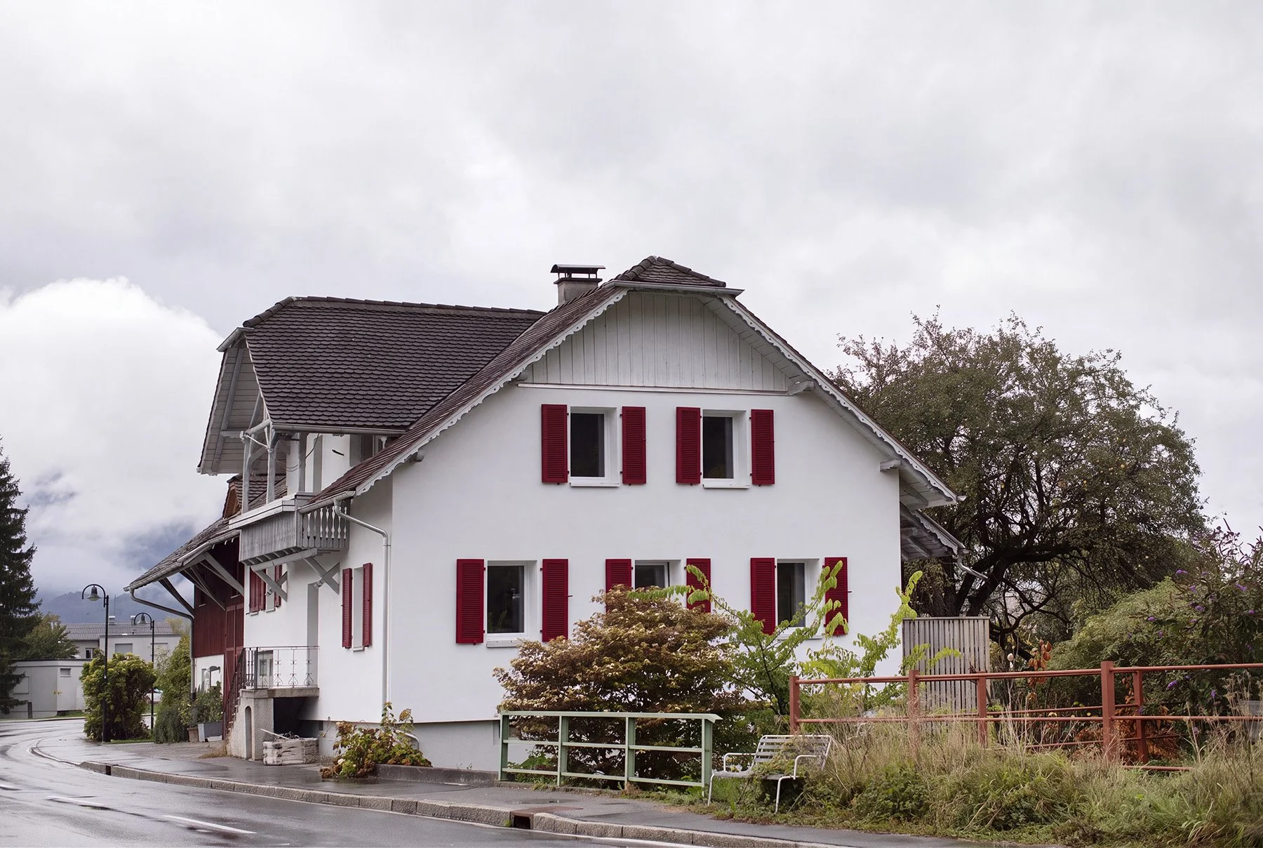 Sanierung W – Sanierte Fassade mit roten Fensterläden.jpg