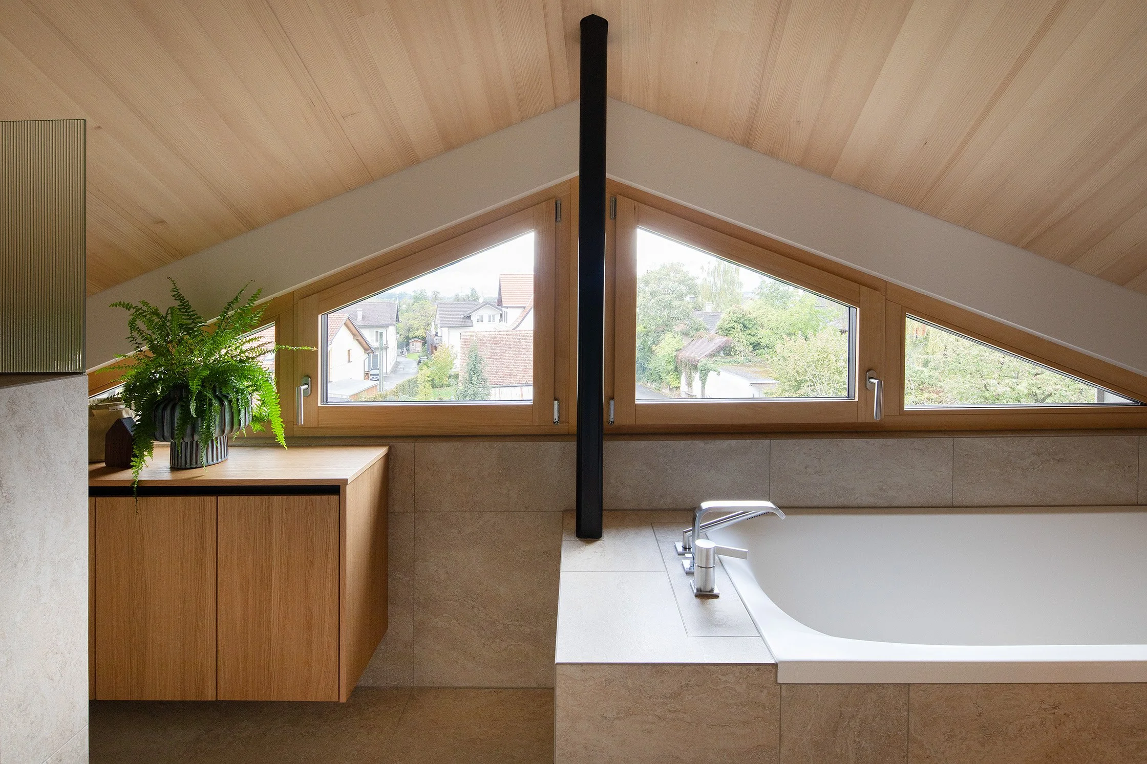 Aufstockung H in Götzis – Badewanne unter der geneigten Holzdecke.jpg