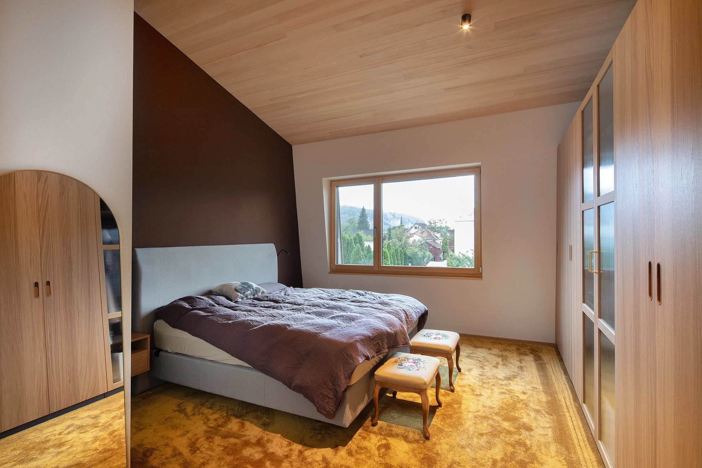 Aufstockung H in Götzis – Schlafzimmer mit Holzdecke und Einbaumöbeln.jpg