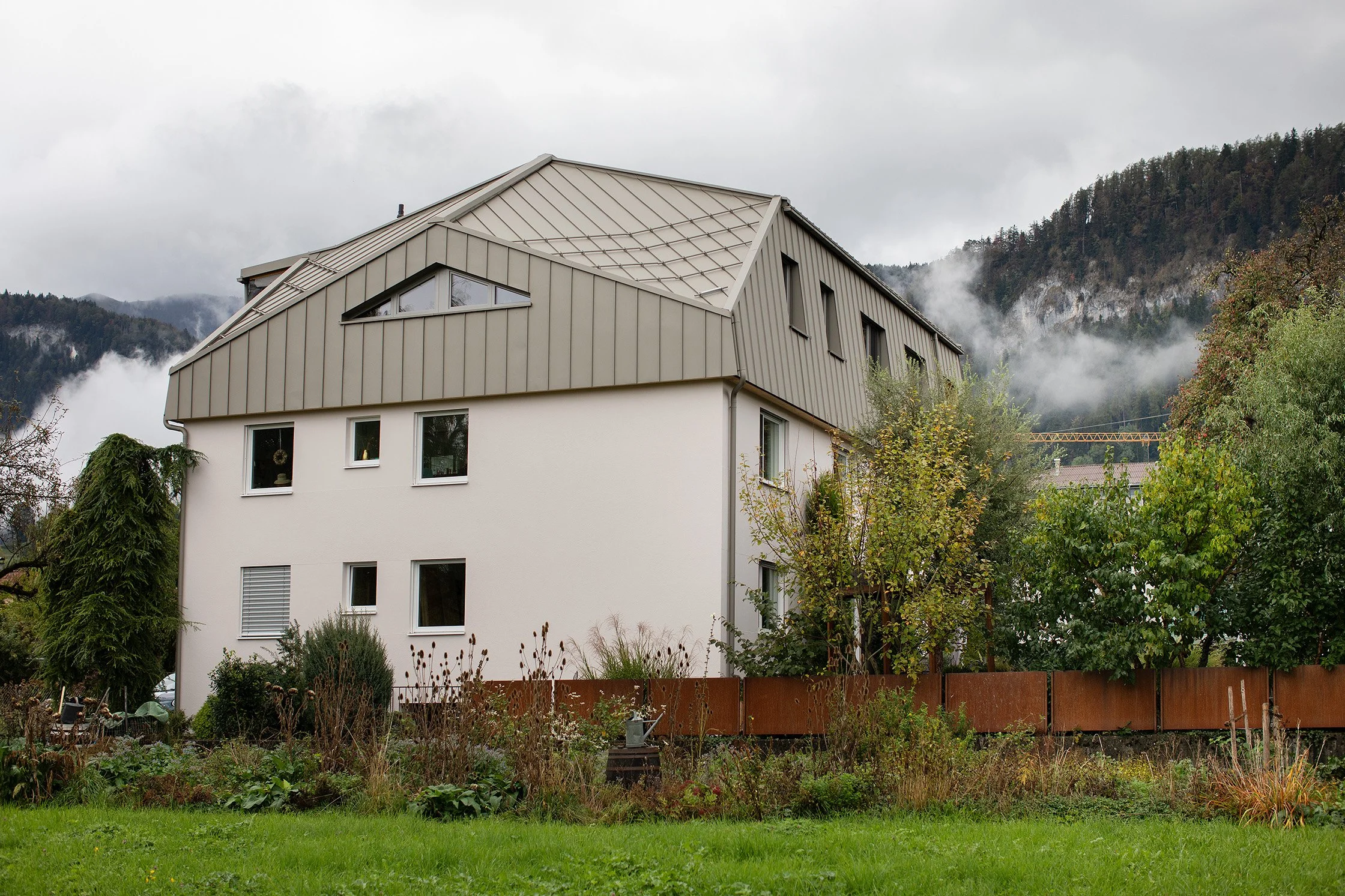 Aufstockung H in Götzis – Metallverkleidete Dachaufstockung aus Gartenperspektive.jpg