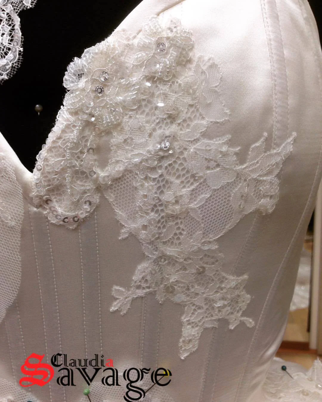 Hand stitched beginnings of lace applique on the corset bodice.