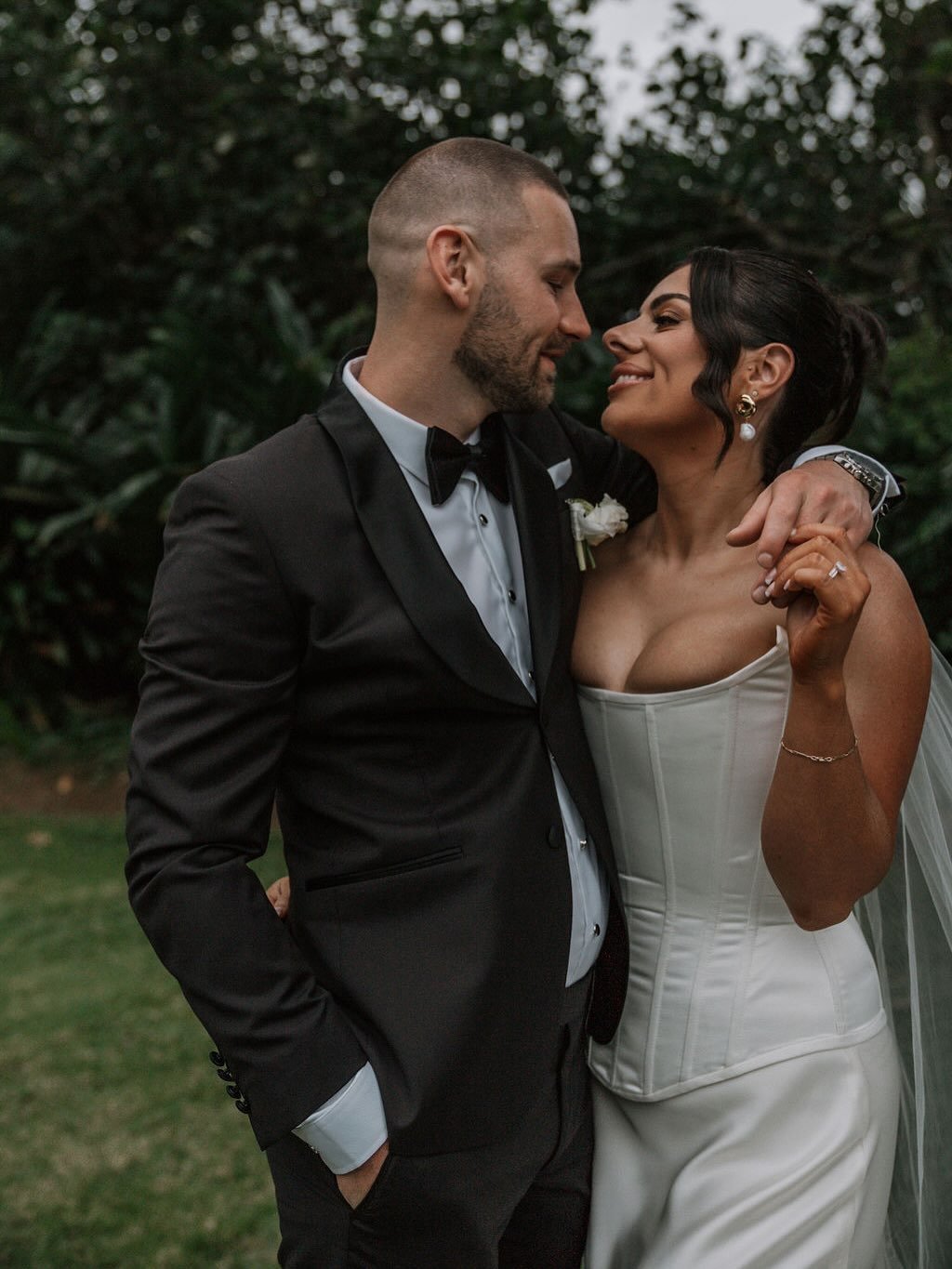 Bride and groom looking at each other, the bride is wearing and custom made corset with visible boning and waist tape