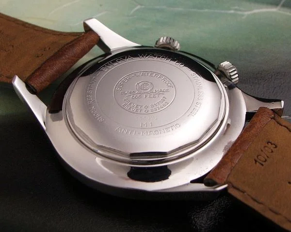 A vintage Bulova caseback with the depiction of a dive helmet Photo credit: scubawatch.org