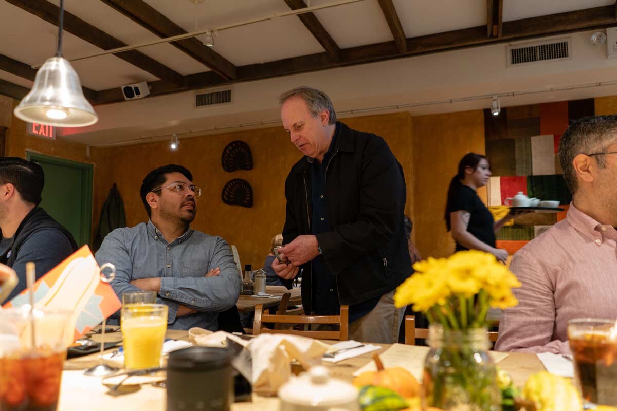 Andrew from Astor & Banks talking to a brunch attendee.