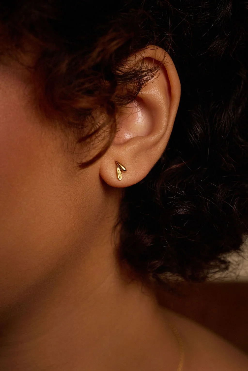 A model wears the minimal, textured gold bud earrings