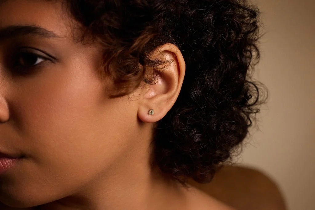 A model wears the delicate gold seedling petal studs