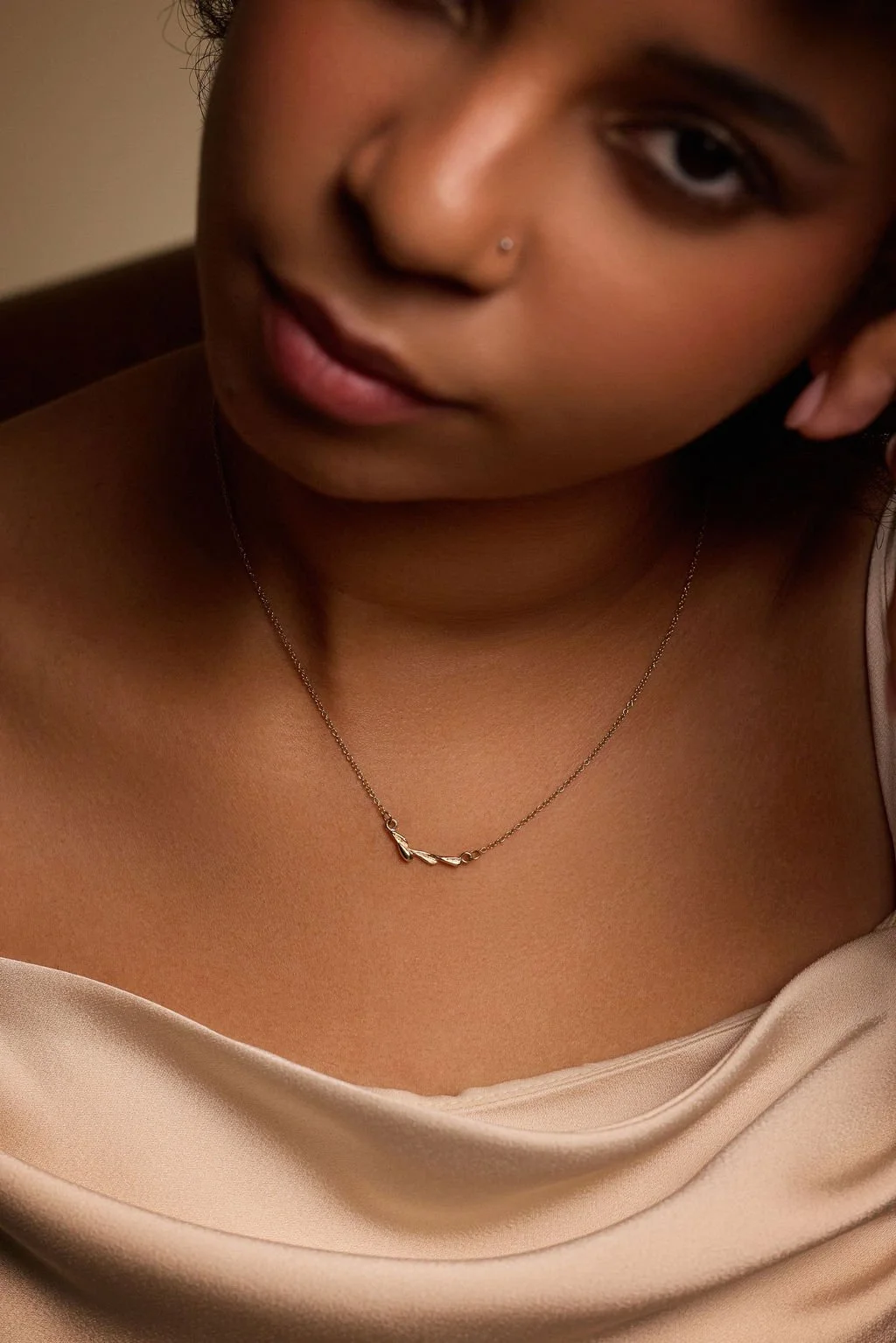 A model wears the sculptural, textured gold Sprig Necklace