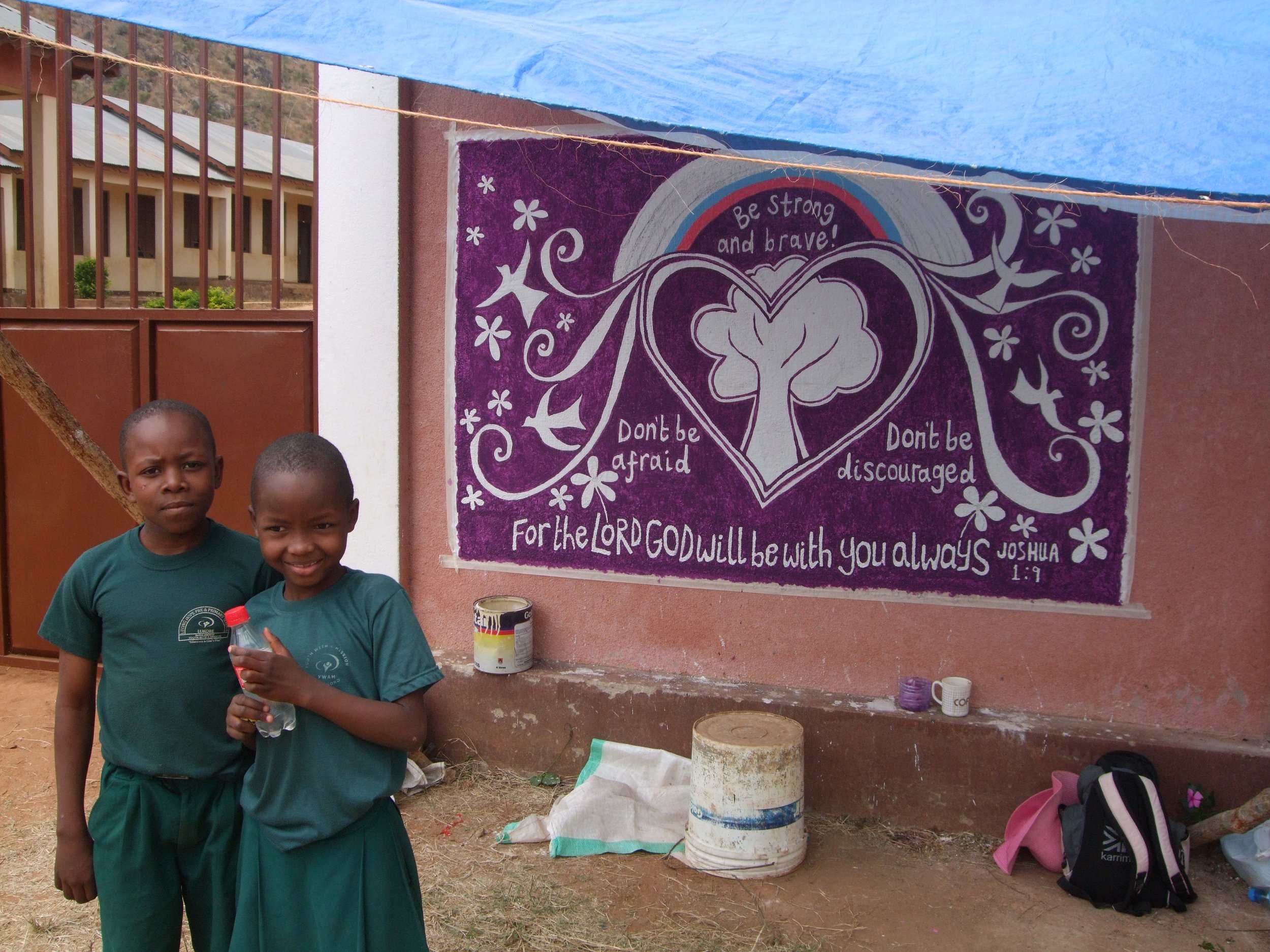 school kids checking out the mural’s progress at Living Hope pre and primary school in Tanzania