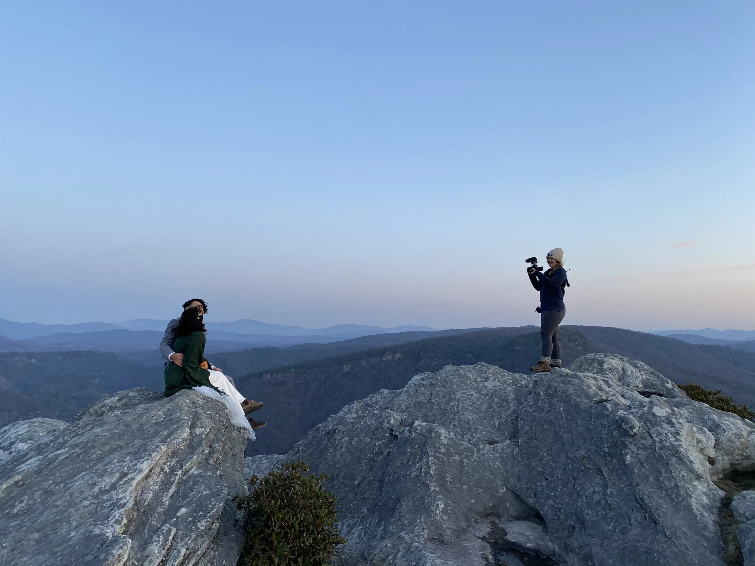 An elopement photographer and videographer captures a couple in the moment atop a boulder