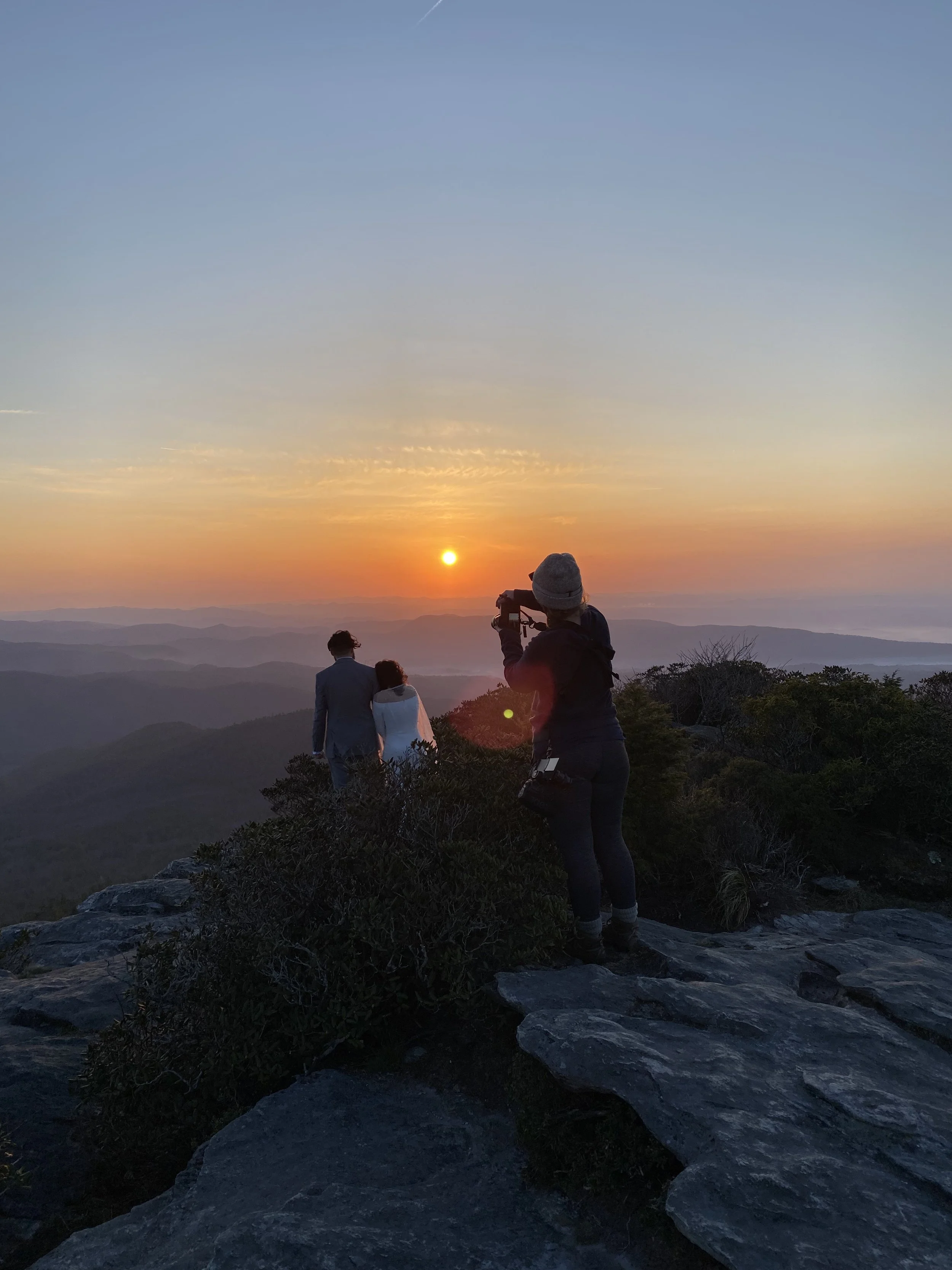 A photographer captures an eloping couple at sunset in the Blue Ridge Mountains