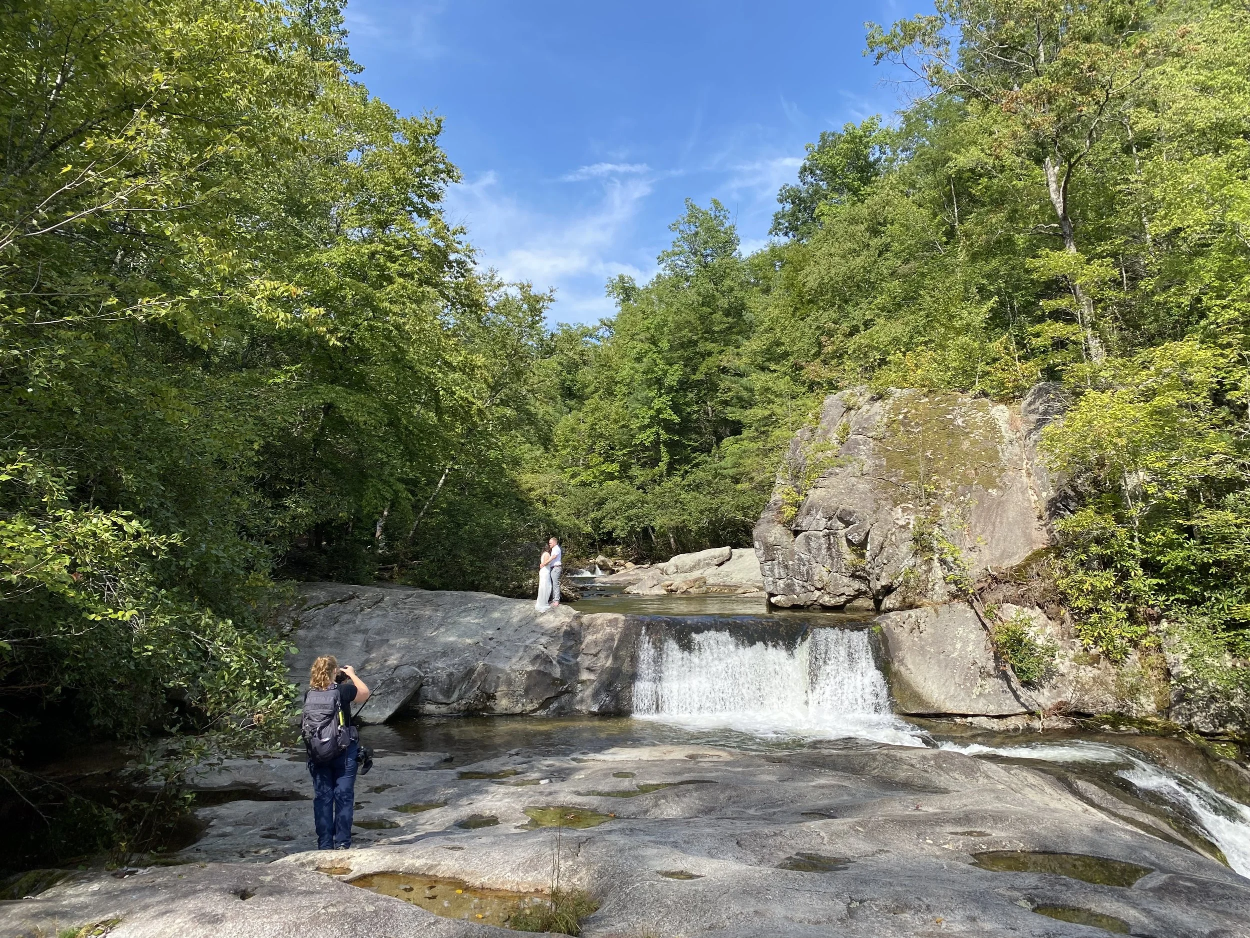 An elopement photographer and videographer captures a couples nuptials atop a waterfall
