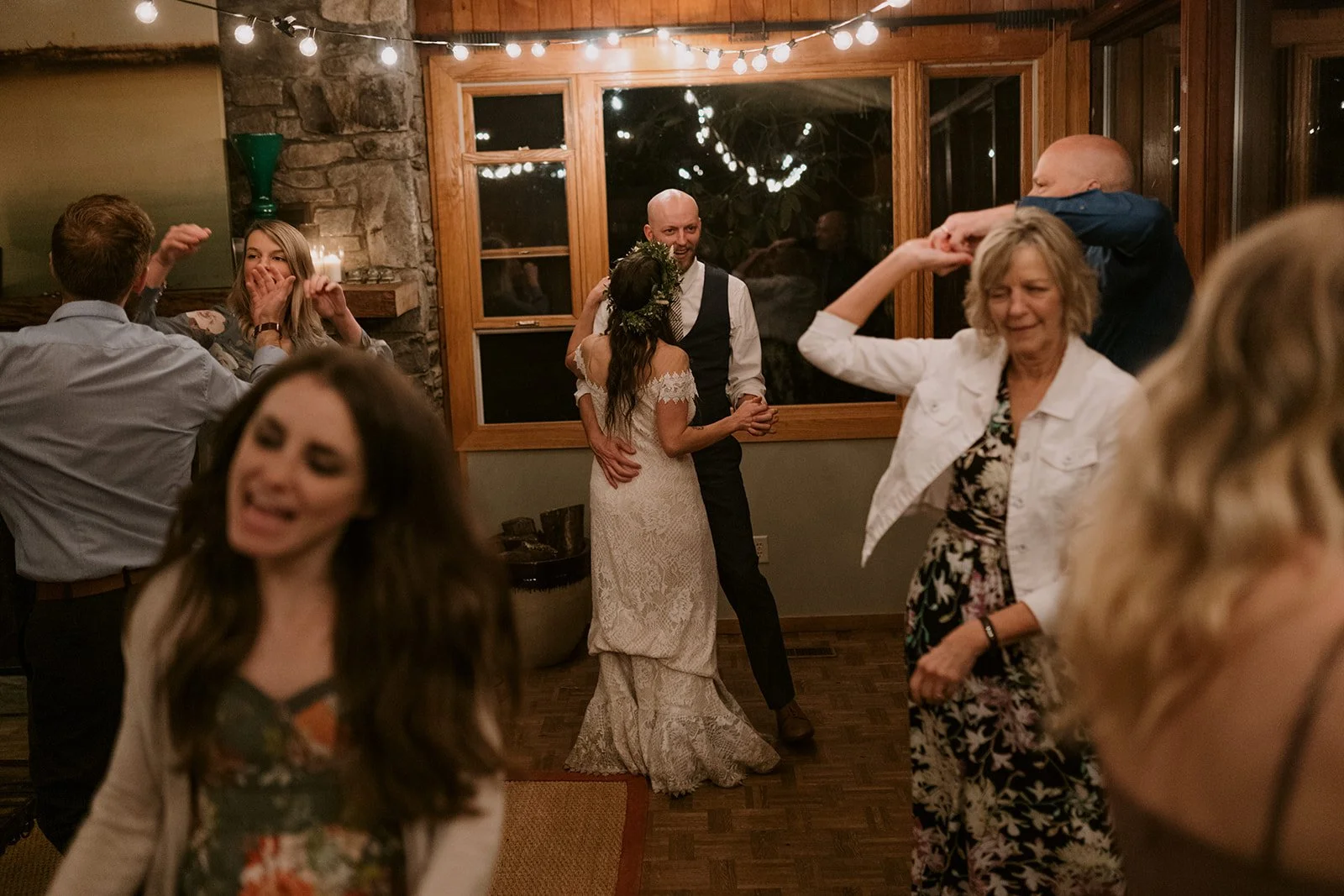 A modest elopement cabin reception features a bride and groom dancing