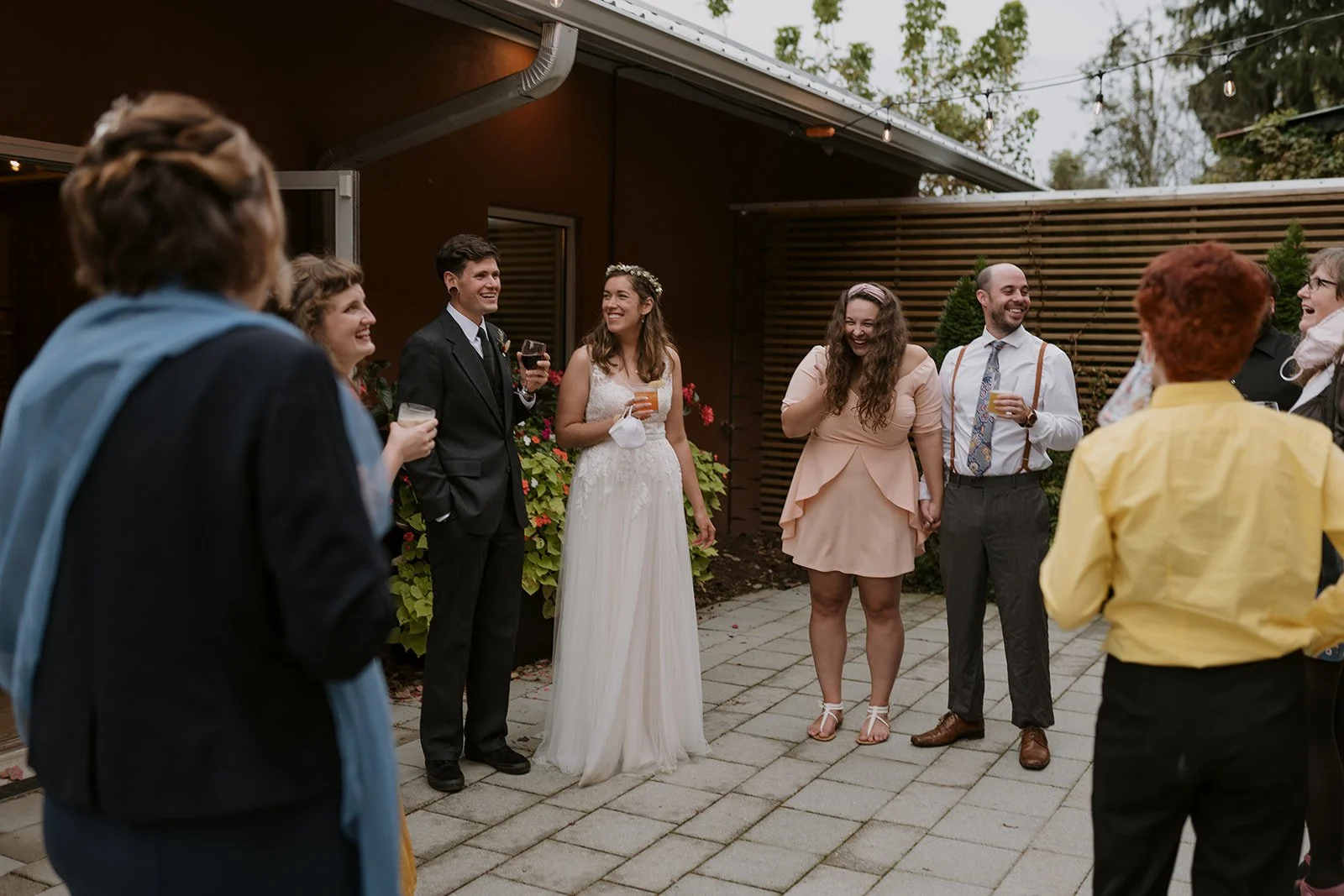 A bride and groom enjoy cocktails with loved ones at their elopement reception