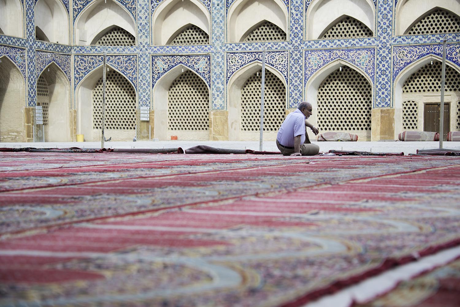 Man Sitting on Prayer Rugs