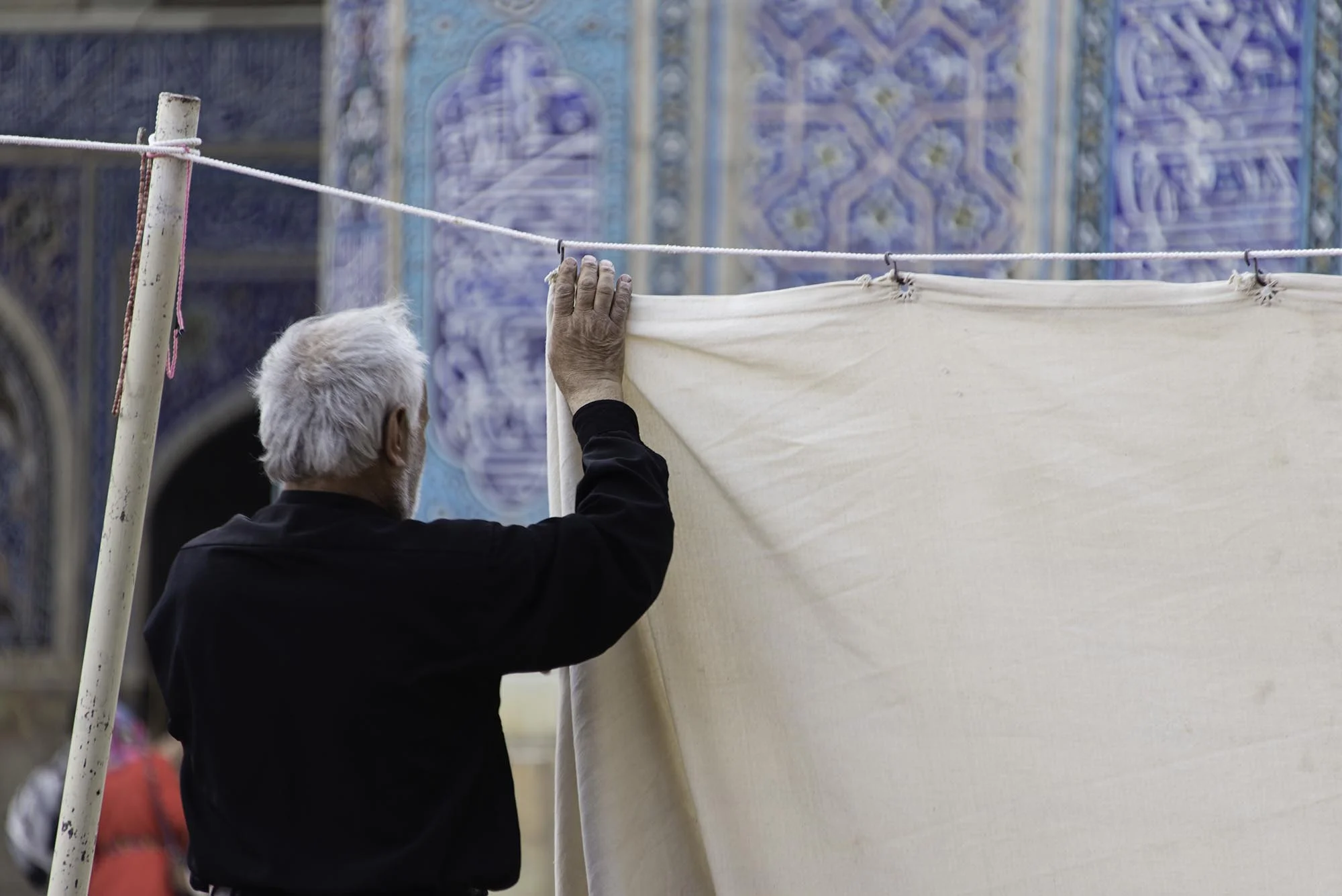 Iranian Man Hanging Curtain Outside Mosque