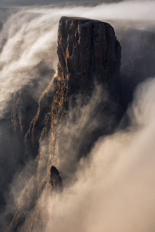 This was one of my finest mornings of landscape photography I have ever experienced. A bland sunrise turned into an epic display of wind and mist coming from Lesotho and falling over the escarpment edge for more than an hour. The falling mist engulfed the landscape emphasizing the dynamic cliffs and pinnacles of a treacherous and beautiful Drakensberg Amphitheatre landscape.