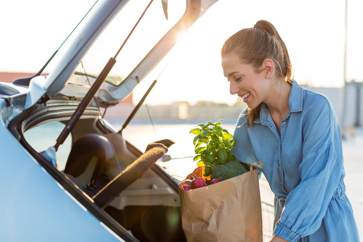 woman putting groceries into car