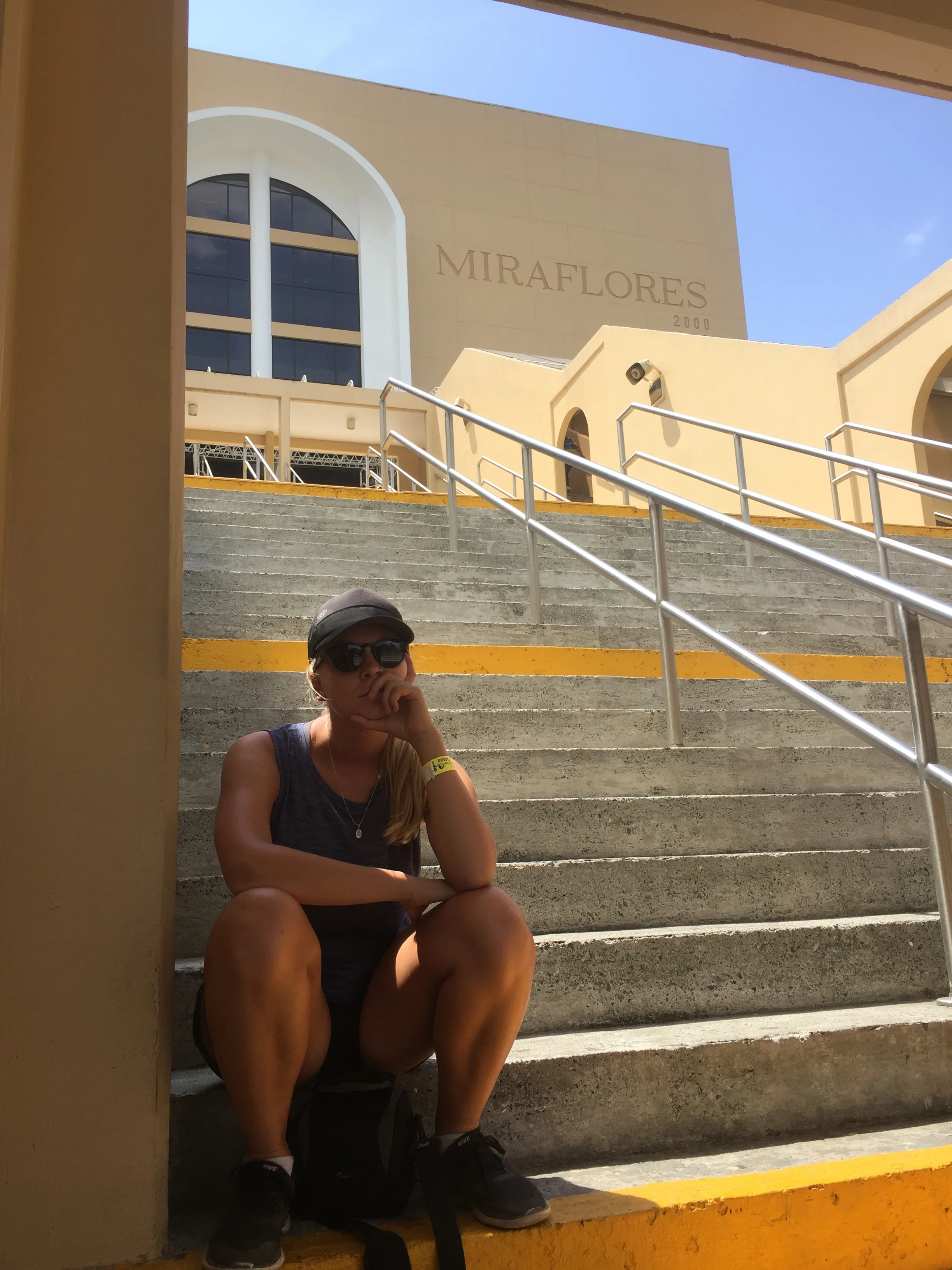 Danielle on the stairs of the Panama Canal's visitor centre waiting for the next Hop-on Hop-off tour bus.