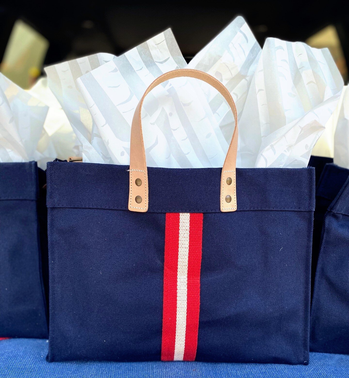 Channeling timeless sophistication with a classic navy tote bag. Elevate your gifting game with a stylish accessory that adds a pop of color to any occasion. 💙❤️