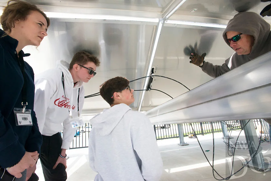 Dan Crews of Today's Power (right) explains the operation of a solar panel he helped build to students (from right) Rachel Glenn 17, Cole Jensen, 15 and Caden Carreno, 14, Wednesday, April 4, 2018 at the Don Tyson School of Innovation in Springdale. (Source North West Arkansas Democrat-Gazette) 