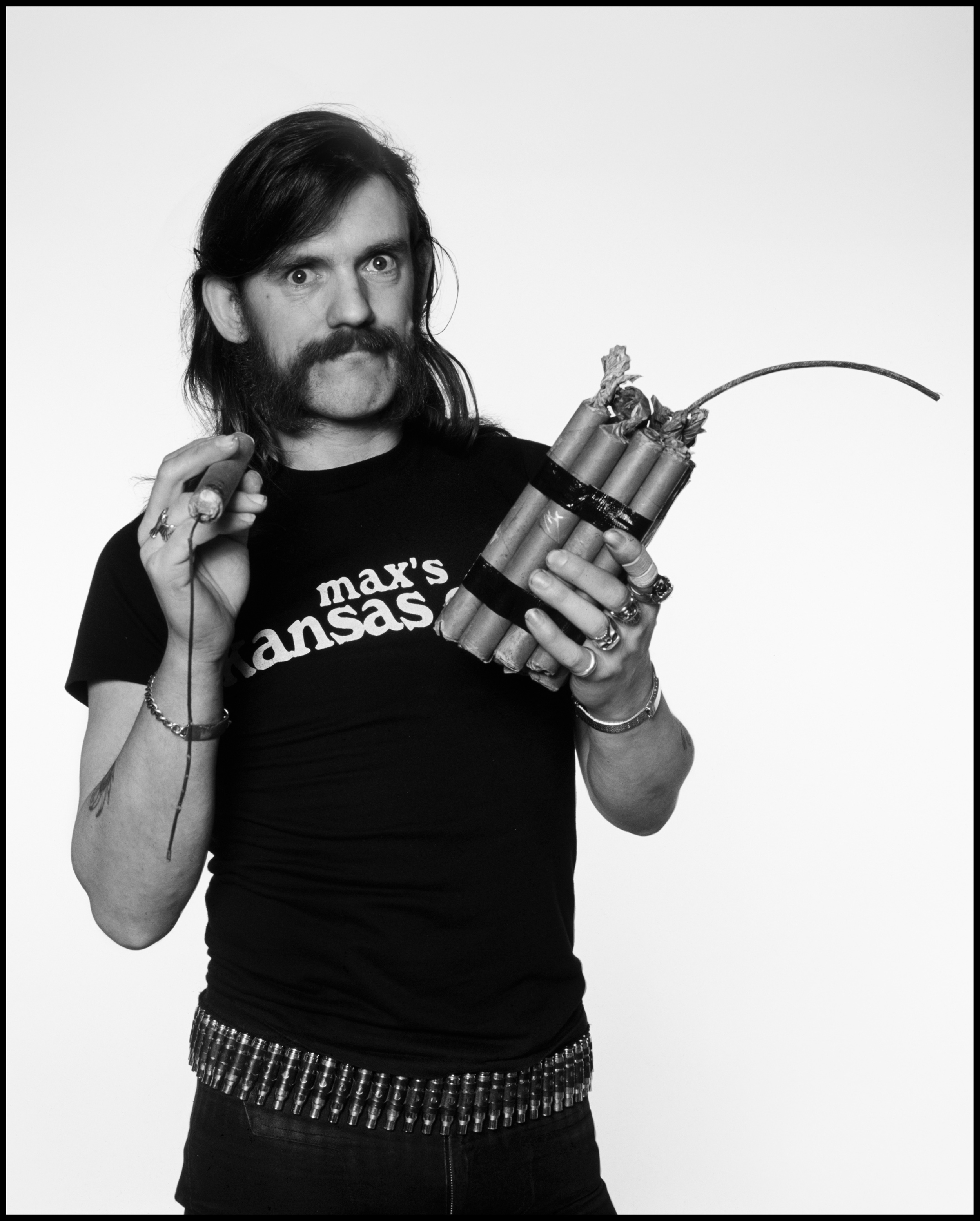 Lemmy - London 1984 I think I first came across Lemmy in 1971 when he was in Hawkwind, he was someone you often saw in Ladbroke Grove or at the Marquee and other watering holes around town, as he was best mates with Mick Farren he became a regular visitor to the NME offices in '75 and '76 before he formed Motörhead. In fact I reviewed Motörhead's first gig at the Marquee in 1977 for the NME and whilst I saw potential in the Uriah Heep/Black Sabbath area I would never have thought they would have been as successful as they became, let alone expect that they would still be going strong thirty five years later. Lemmy is a gruff, slightly imposing, yet adorable kind of a Rock Star, quite malleable too, always happy to oblige when one needs a quick photo for a Magazine. This picture was originally shot for the cover of Time Out in 1984 and the 'session' lasted about ten minutes. Lemmy arrived, took off his leather jacket, grabbed the fake dynamite and stepped into the studio grinning. He then did 24 assorted poses, giving me everything I needed on exactly two rolls of film. Knowing that all good photographers were skilled in the art of quick shoots, he put the dynamite down, put his leather jacket back on and left the building.