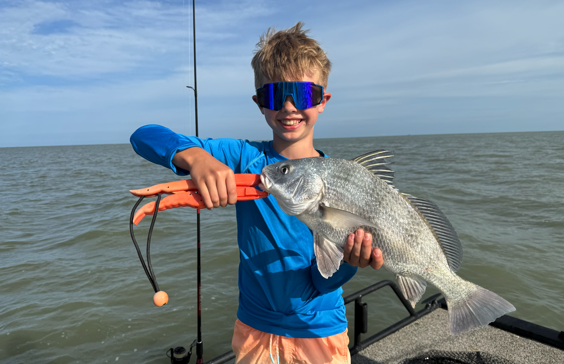 Child proudly holding big fish