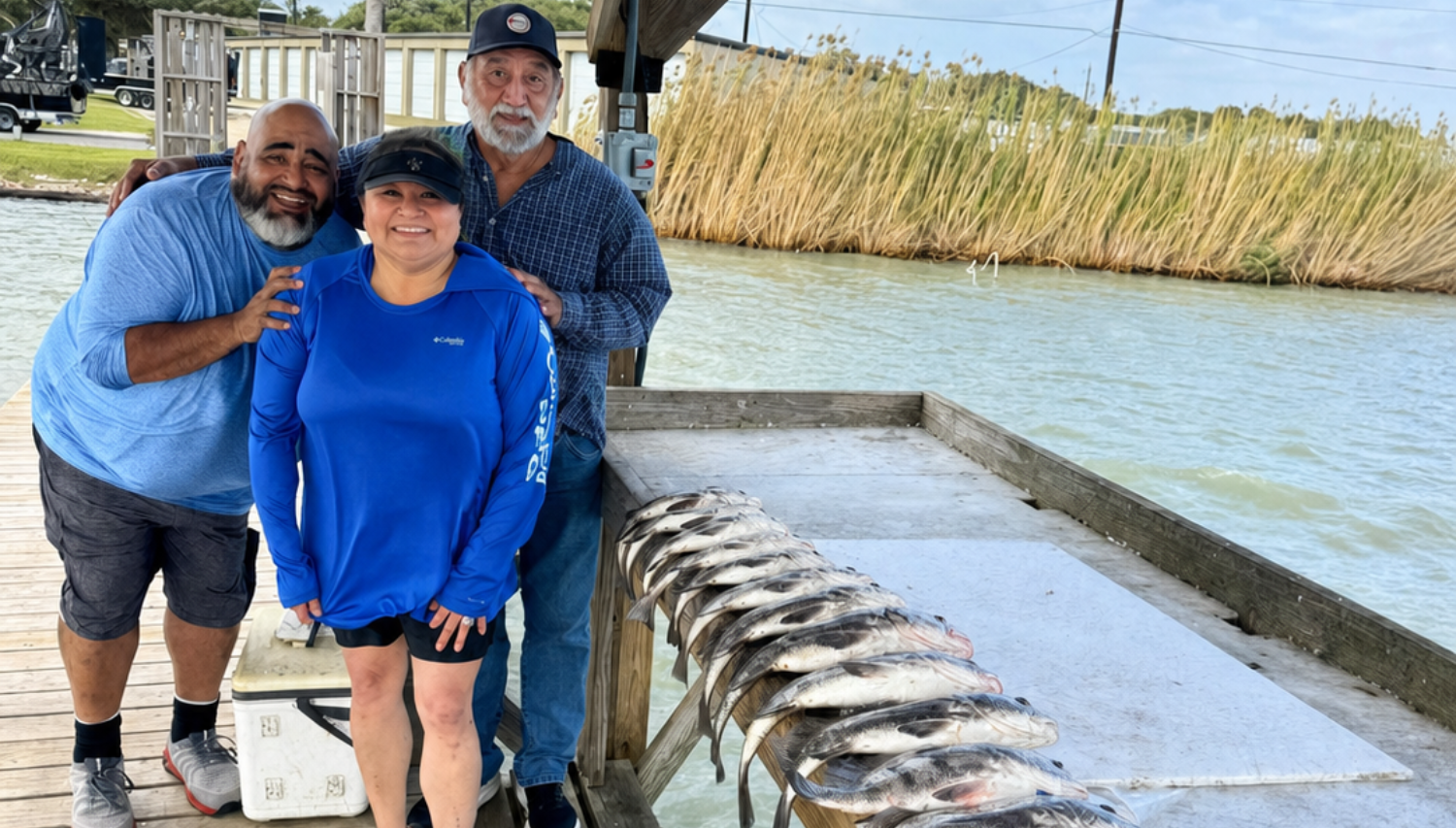 Group of three anglers posing on a Rockport dock with a limit of black drum laid out after a Texas Crew’d fishing trip.