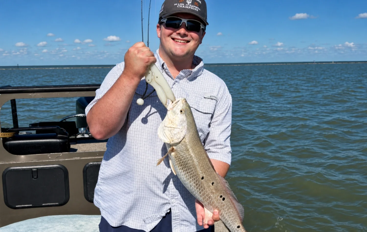 Smiling angler holding a fish on a Texas Crew'd bay fishing charter