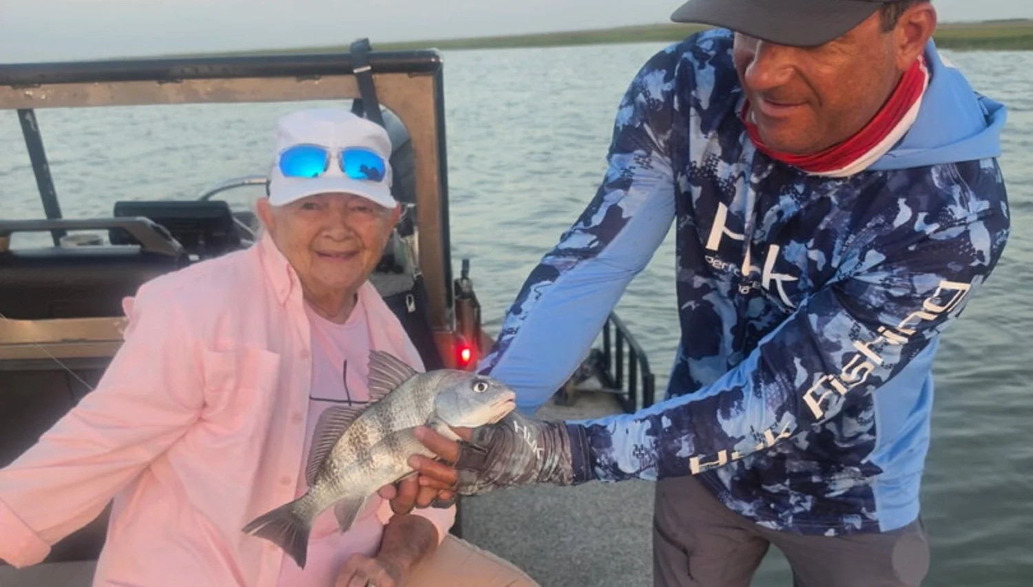 Captain Blake helping Mary M. with a black drum on a Rockport bay fishing trip