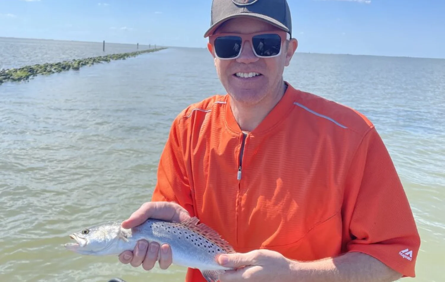 Texas Crew'd guest holding a speckled trout during the May 3 2026 Rockport bay fishing trip