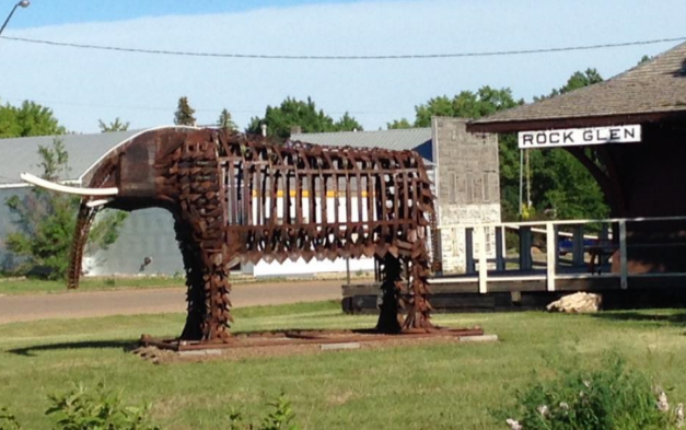 “Oliver” Rockglen & District Tourism is pleased to display the metal sculpture Oliver, designed and created by Melvin Monea. Oliver represents the fossilized remains of a four tusked mastodont found just west of Rockglen and commemorates our history before and during the last ice age when, from 16 million to 10 thousand years ago, mastodonts roamed our hills and valleys. This metal sculpture of “Oliver” is also a tribute to life in early years of the Rockglen region when the Town boasted of having several implement dealers. Mr. Monea has created this impressive metal sculpture from many of their Oliver and other machinery parts as a lasting legacy to our farming community and to our rich archeological history. You can see several of “Oliver’s” genuine fossils here at the Effie Mattson Nature Walk and Archeological Centre and at the Royal Museum of Natural History in Regina. 