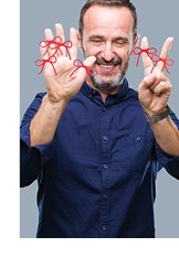 Photograph of man holding up seven fingers, six which are tied with red string bows to signify reminders.