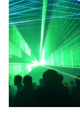 Photograph of a laser light show illuminating silhouetted attendees.