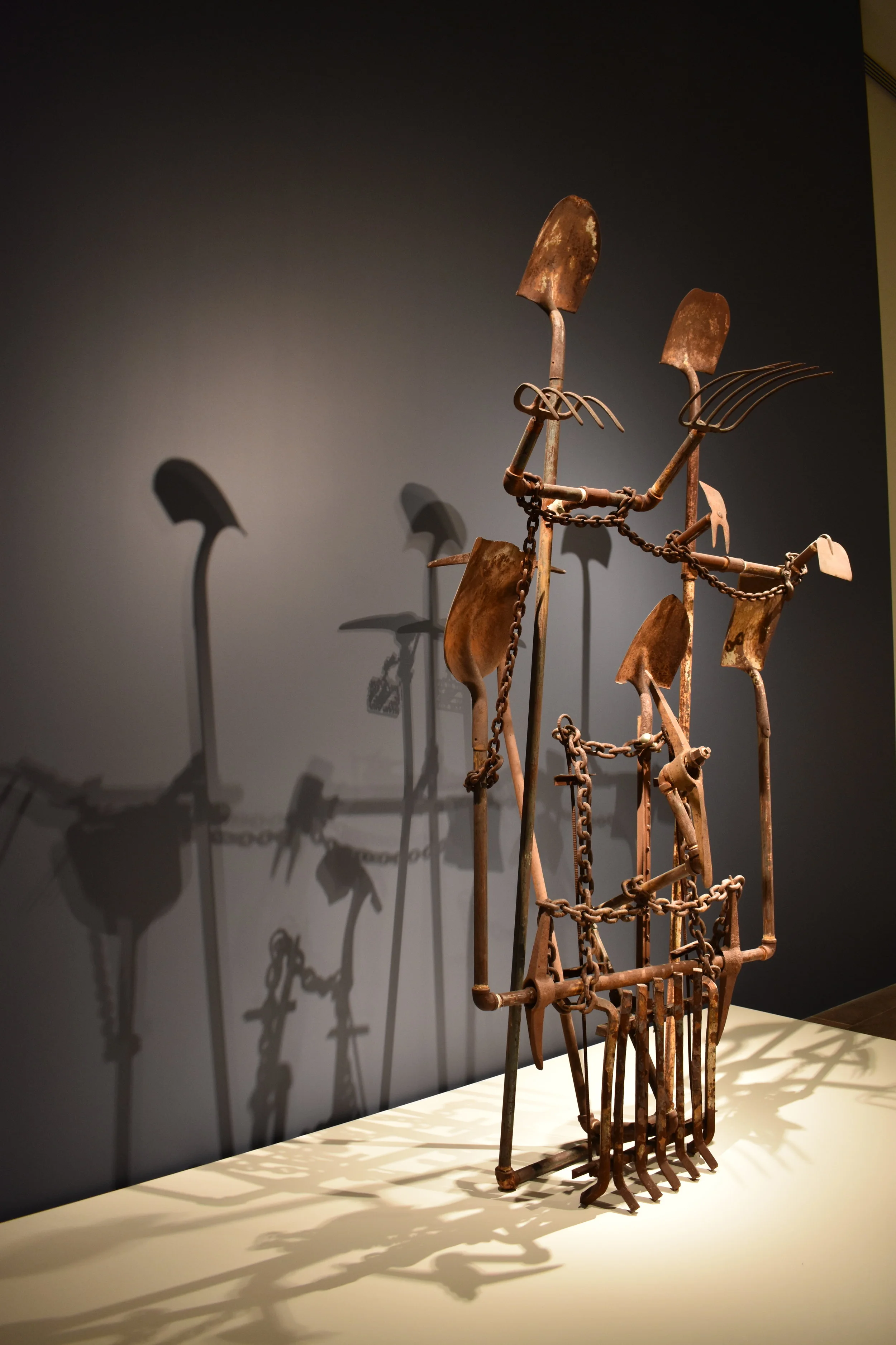   Four Hundred Years of Free Labor by Joe Minter   The name says it all - rusted tools stand at attention, hauntingly displayed to throw stark long shadows against the dark dusty blue gallery wall. 