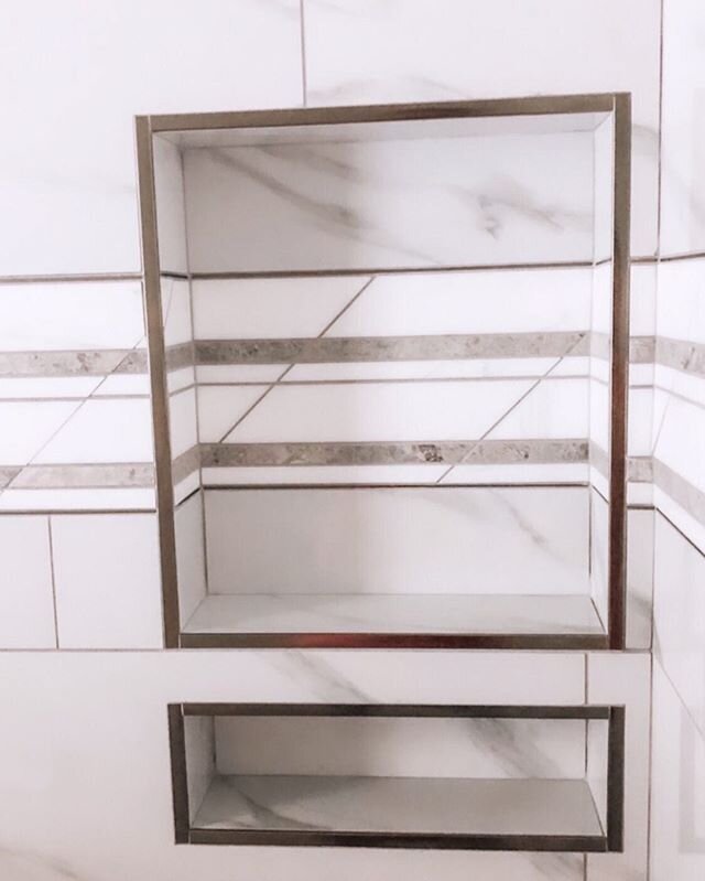 Polished chrome trims out these🧴 and 🪒 stacked niches so nicely. Plus our amazing installers lined the top and bottom of this marble deco band with polished chrome trim and carried it through the niche.  Custom tile work takes time and requires exp