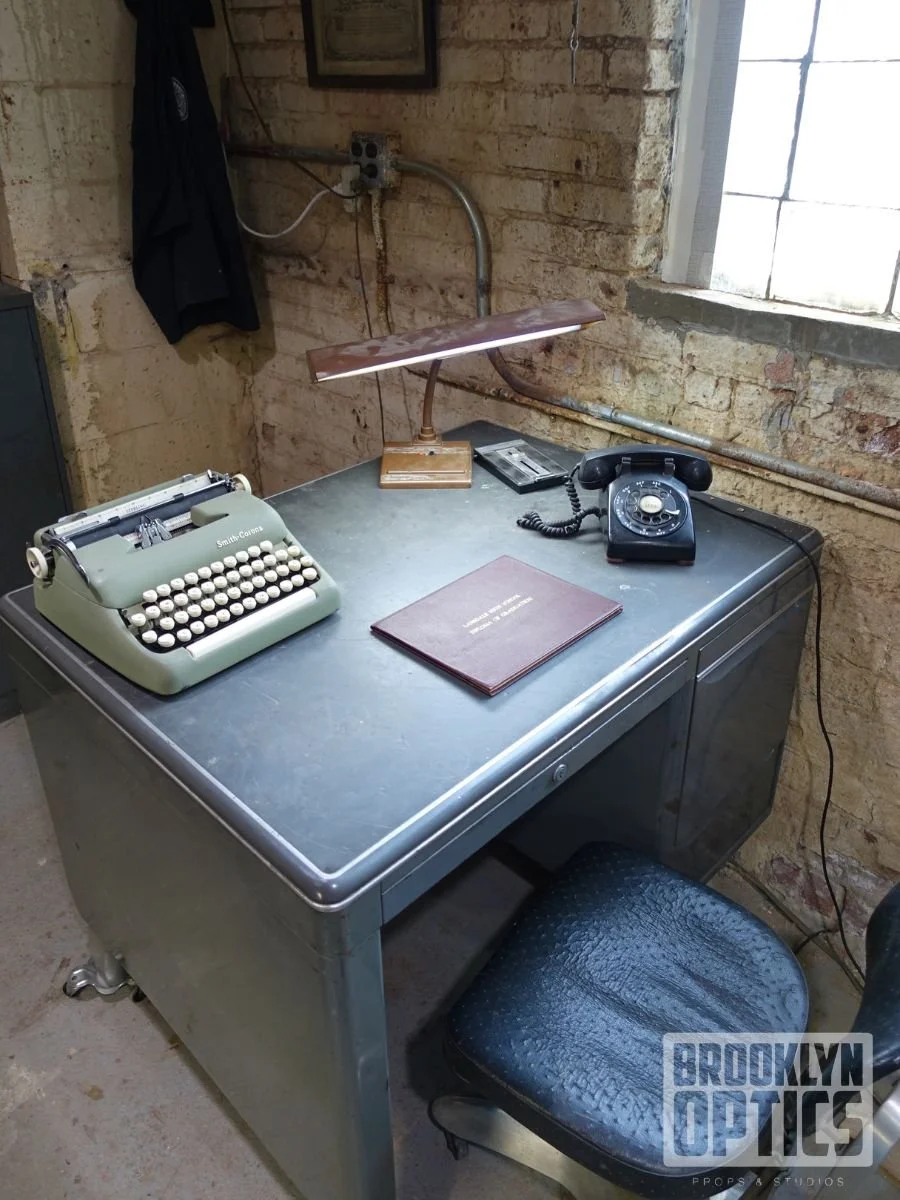 A vintage black Royal typewriter with round keys on a rustic wooden table.