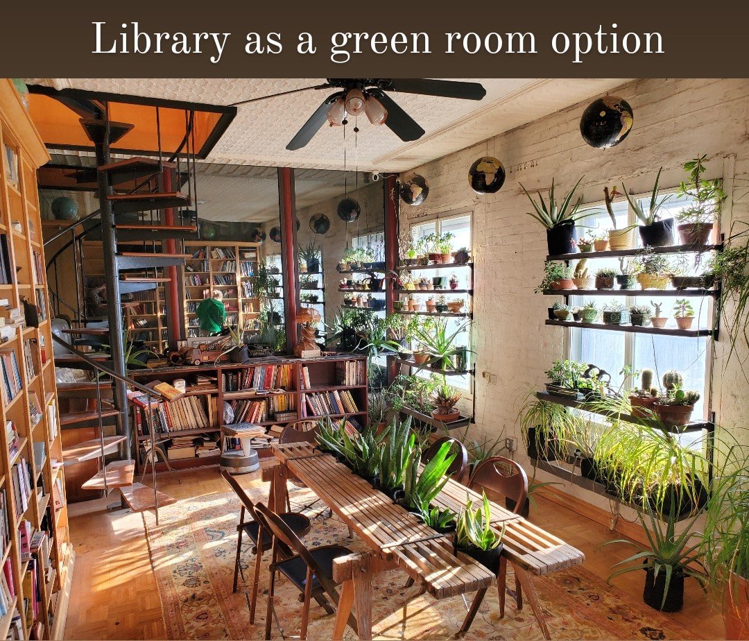 A cozy room with bookshelves, a spiral staircase, a wooden dining table with chairs, and numerous potted plants on shelves and windowsills, creating a lush, green space.