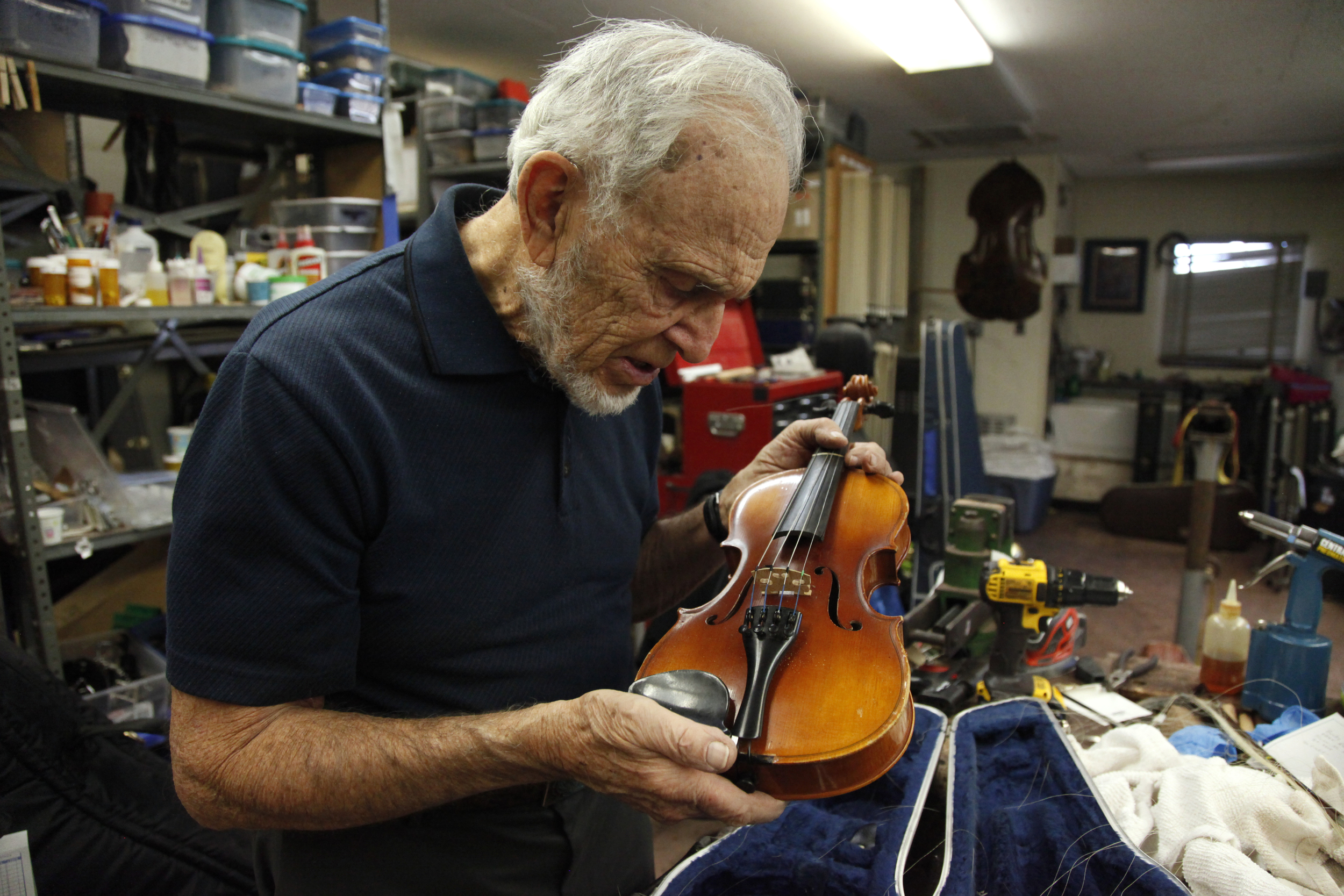  Ned Bloomfield inspects a violin in the Tucson Unified School District's instrument repair shop on December 17, 2015.&nbsp; 