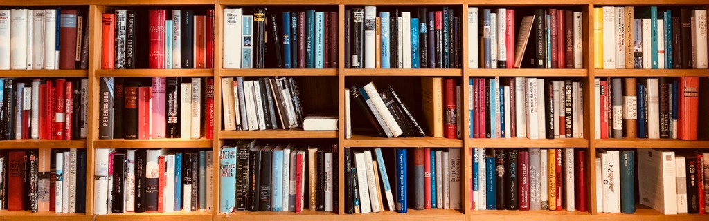 brown-wooden-shelfs-fully-packed-with-books-in-a-library-picture-id900301626.jpg