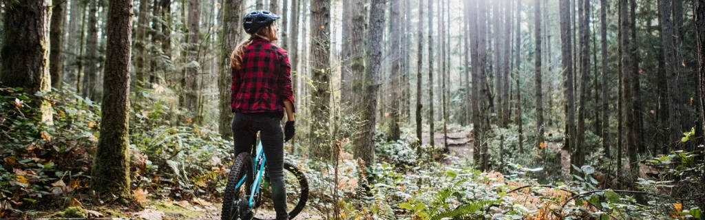 woman-mountain-biking-on-forest-trails-picture-id1077207188.jpg