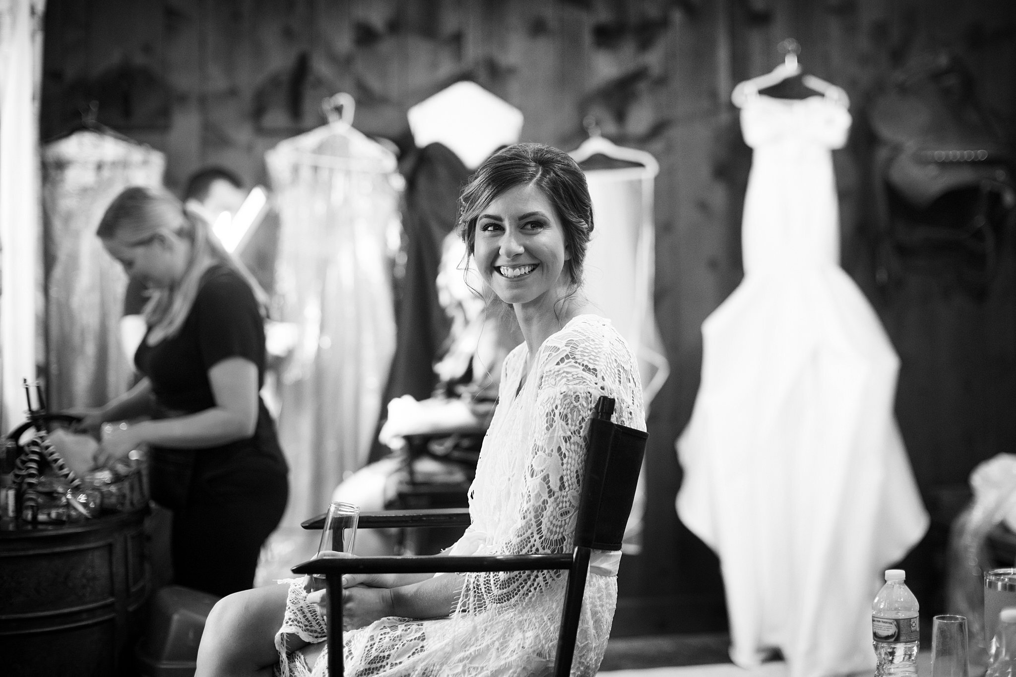  Smiling bride sitting in makeup chair. 